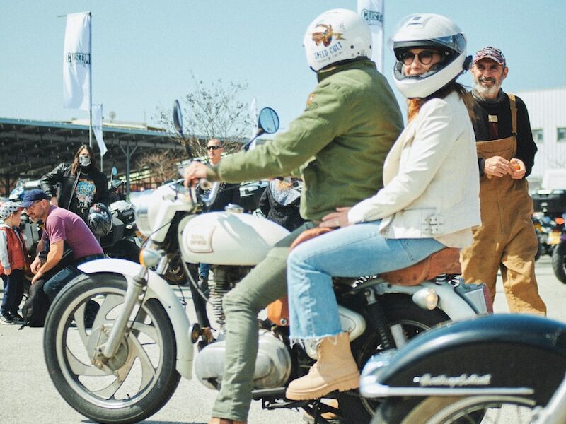 a group of people riding motorcycles down a street